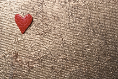 Red heart in the up left corner on a silverish background.の写真素材