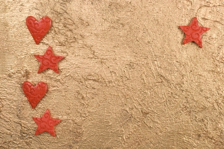 Red hearts and stars on a golden surface.の写真素材