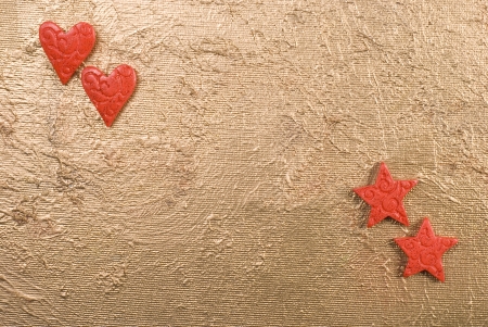 Red hearts and stars on a golden surface.の写真素材