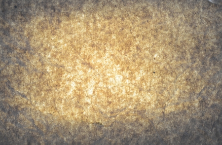 Grey paper with brown yellow glow spot in the middle.の写真素材