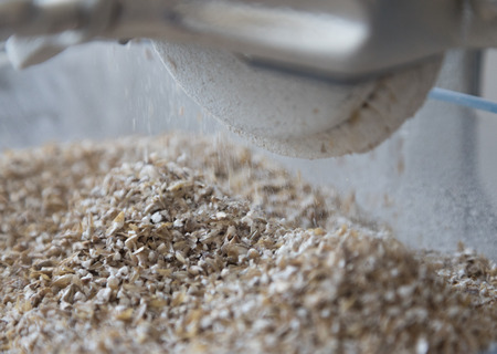 Malt being grinded in homebrewing conditions with a small scale grain mill.の写真素材