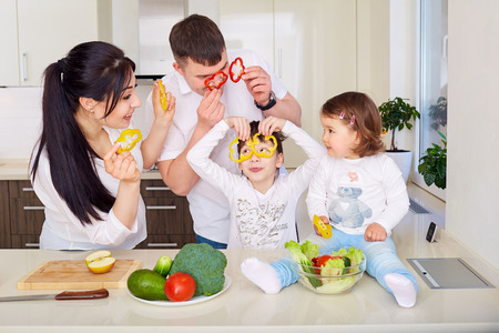 Family playing with vegetables in kitchenの写真素材