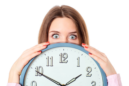 Woman holding clock  with wondering eyes.の写真素材