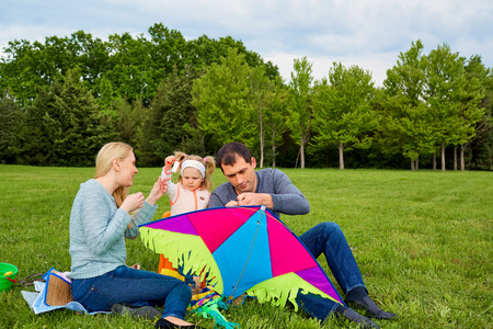 Happy young family with flying a kite in the park.の写真素材