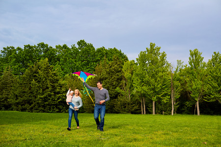Family with flying kite in parkの写真素材
