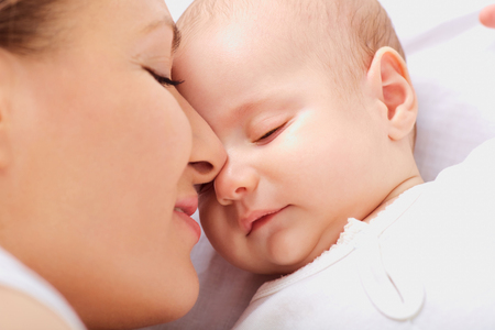 Closeup on mother kissing sleeping babyの写真素材