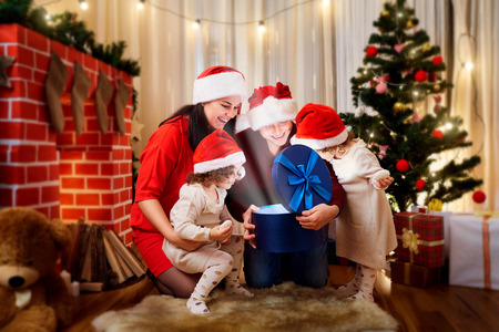 Happy family at Christmas, a happy New Year. Mother, father and children open gifts in the room with the decor.の写真素材