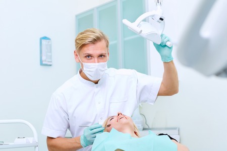 Dentist on a workplace with the patient in a stomatologic clinic of his officeの写真素材