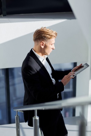 A man in a suit with  tablet in his hand  the office.の写真素材