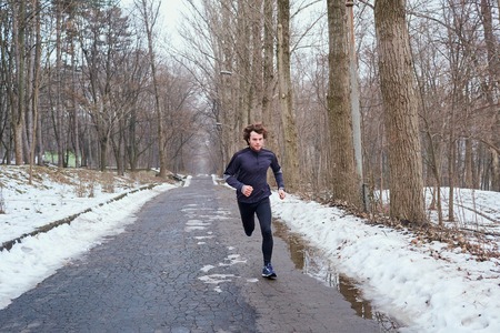 Young runner running in the park in spring, autumn on nature.の写真素材