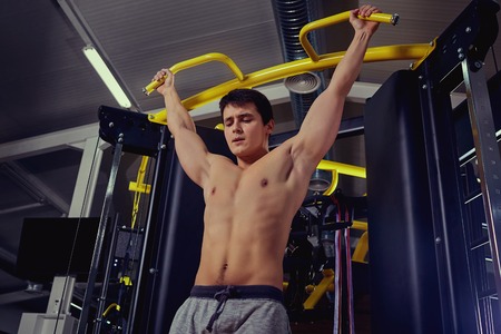 Athlete makes pulling up in the gym.