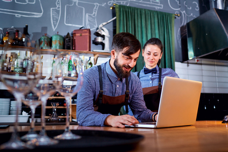 The bartender barista with a laptop on bar.の写真素材