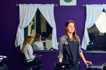 Portrait of a female hairdresser in  beauty salon indoors.の写真素材