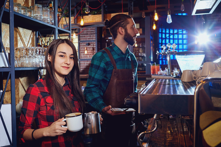 Girl barista bartender waiter in uniform making coffee at the bar.の写真素材