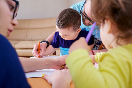 Parents and children draw together in the room.の写真素材