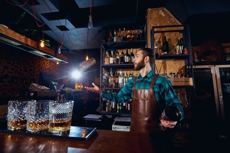 The barman juggler throws up a glass for  cocktail at bar.の写真素材