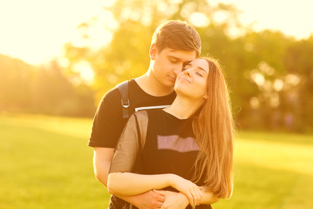 A loving couple hugs in the park at sunsetの写真素材