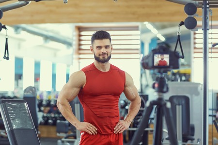 athlete bodybuilder makes a video in the gym.