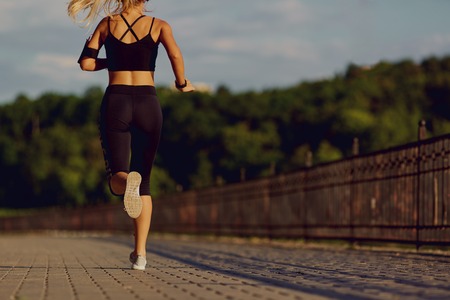 Girl runner jogging in the park in morning  evening.の写真素材