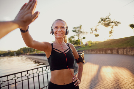 Runner girl giving high five in the park.の写真素材