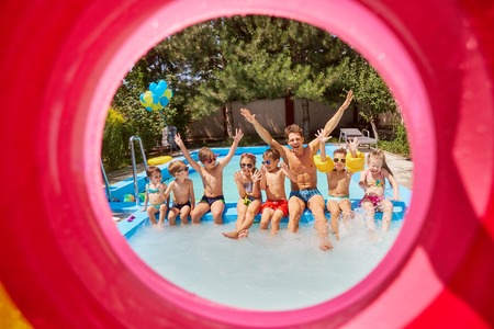 Children with a tutor educator in the pool in the summer camp.の写真素材