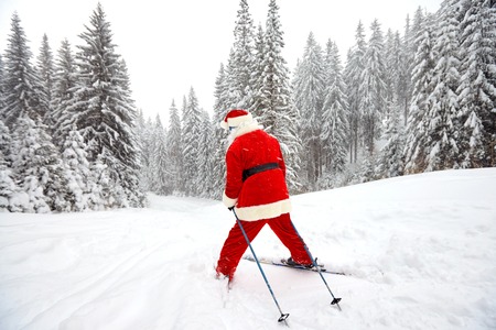 Santa Claus skiing in the mountains on snow in winter in Christmas. Christmas in the mountains.の写真素材