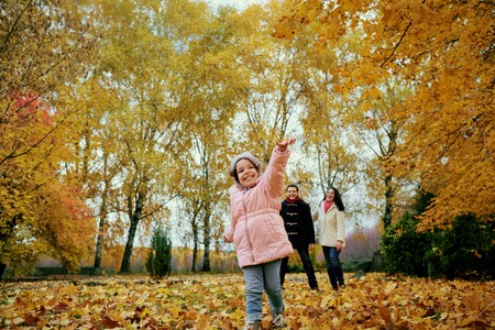 Happy family playing in autumn park. Children play with their parents in nature in October.の写真素材