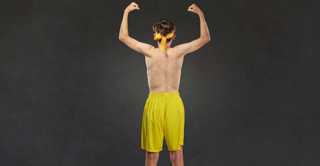 Funny thin guy in sportswear. Back view. Comic humor concept in sports.の写真素材