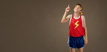 A thin funny guy in sports clothes shows his finger up. Concept ideas.の写真素材