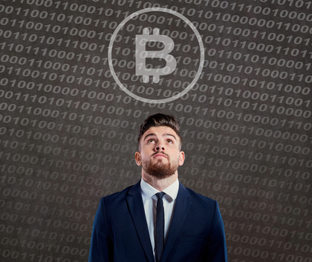 Businessman looking with question at bitcoin.の写真素材