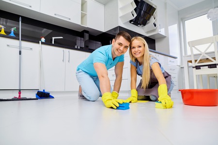 Young family couple doing cleaning in the kitchen.の写真素材