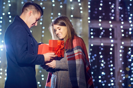 A man gives a box with a gift to his girlfriend outside. Concept Valentines Day.の写真素材
