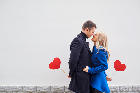 A loving couple in a coat with hearts in hands on a gray background for text. Valentines Day.の写真素材