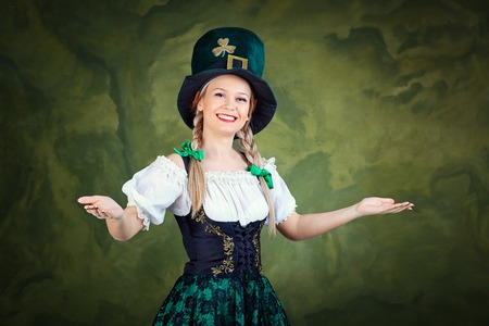 The girl in the suit of St. Patrick is welcome on a green background. St. Patricks Day.の写真素材