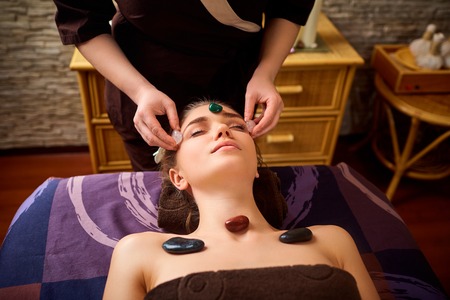 Stone massage is a facial massage for a woman in the beauty center.の写真素材