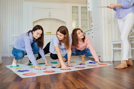 A group of friends play fun in games on the floor indoors.の写真素材
