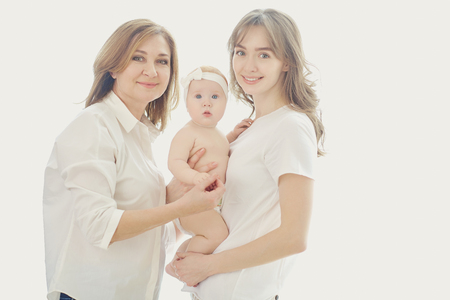 Mother, grandmother and toddler on hands on a white background. A family.