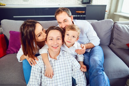 Happy family smiling sitting on sofa in room. Happy family.の写真素材