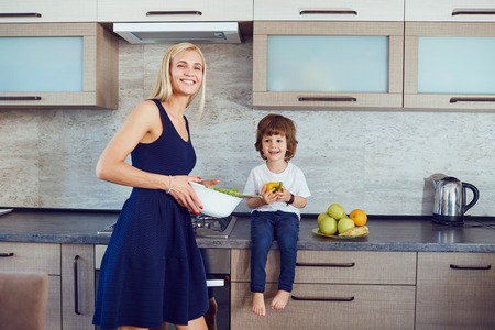 Mother and son in the kitchen indoors.の写真素材