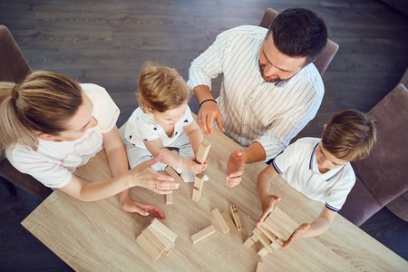 Top view of the family playing board games at a table inside the room.の写真素材