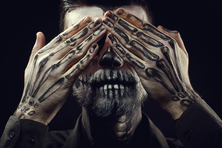 Portrait of man with Halloween skull makeup on the black background.の写真素材