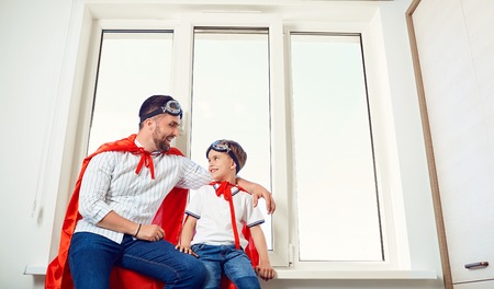 Father and son at the window in the room. Fathers Day.の写真素材