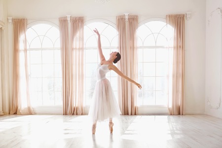 Ballerina dancing in a studio on white background window.の写真素材