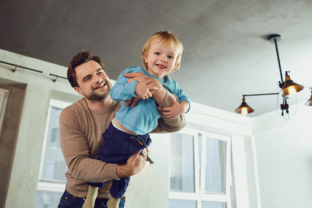 The father plays with his son in a superhero, a pilot in the room. Fathers Day.の写真素材