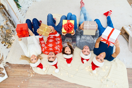 A group of friends with gifts at a Christmas party.の写真素材
