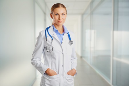 Doctor blonde in lab coat in the clinic on the background for text.の写真素材