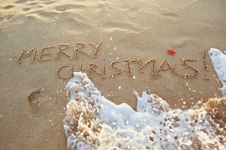 The inscription Merry Christmas on the sand on the beach. The concept of Christmas by the sea.