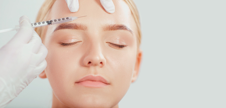 Cosmetic injection to a young woman. Beautician makes the injection of a girl lifting.の写真素材