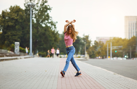 Happy woman walking  during the day on the streets.の写真素材