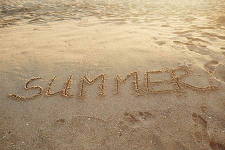 Word summer made on sandy surface of tropical beach in sunlightの写真素材